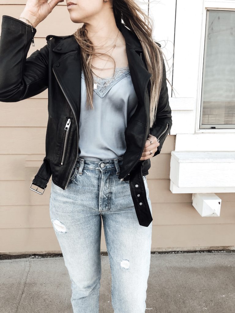Leather jacket paired with satin cami, jeans, and black booties. 