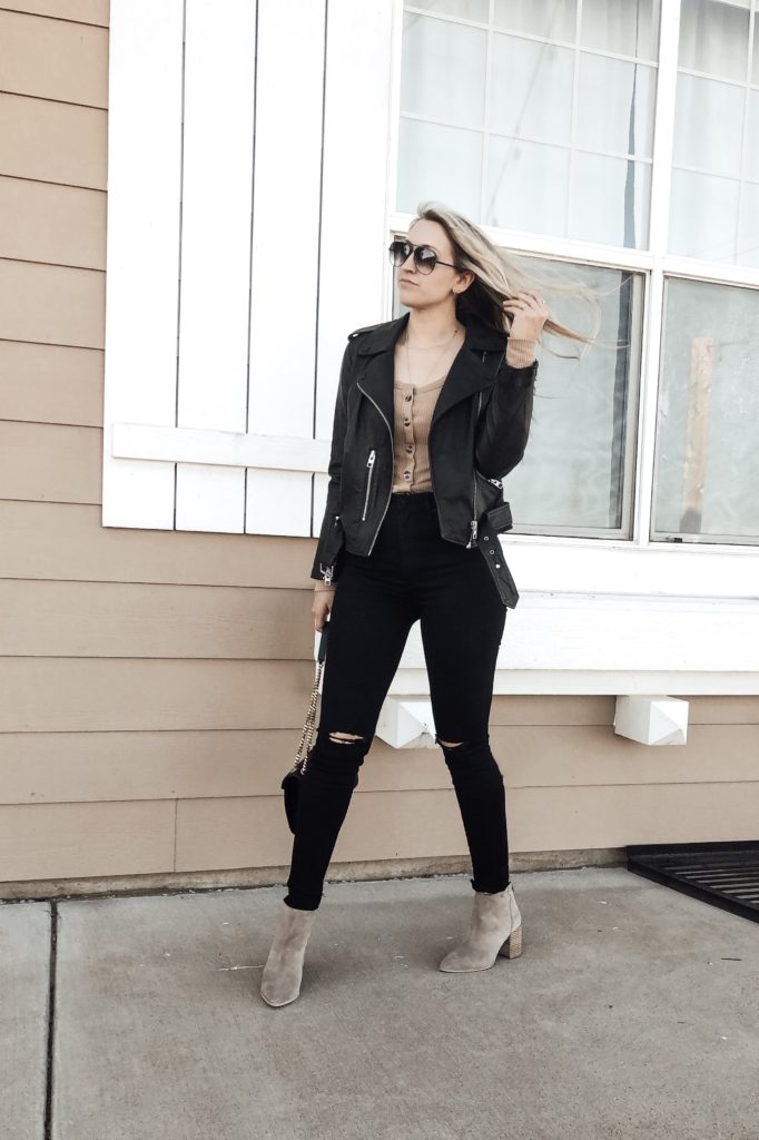Styled with black denim, a button-up top, and booties.