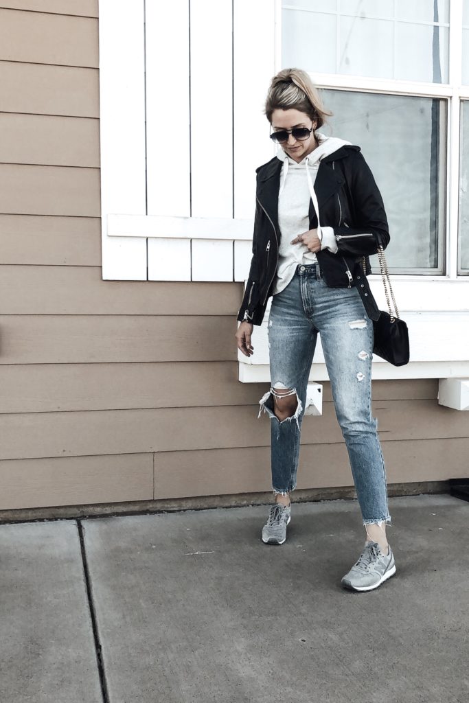 Leather Jacket paired with sweatshirt, jeans, and sneakers. 